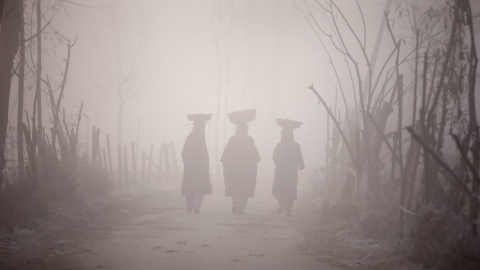 Mujeres Kashmiri portan cestas sobre sus cabezas mientras caminan entre una densa niebla a primera hora del día. Srinagar, India. REUTERS/Danish Ismail