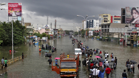 Personas caminan por las calles inundadas de Chennai (India) debido a las fuertes lluvias que han sacudido al país. Chennai. REUTERS/Stringer