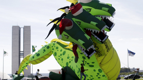 Unos brasileños levantan un dragón inflable contra la inflación, el desempleo y las altas tasas en frente del Congreso Nacional en Brasilia, Brasil." REUTERS/Ueslei Marcelino