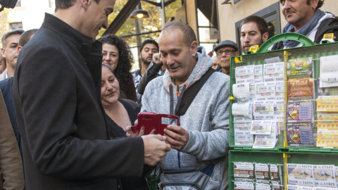 El secretario general del PSOE, Pedro Sánchez compra un cupón de la ONCE y conversa con varios ciudadanos en Palma de Mallorca, antes de participar en un acto de campaña  en la localidad de Inca. EFE/Cati Cladera