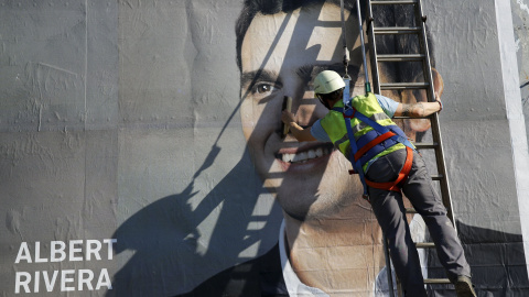 Un operario termina de colocar un cartel de Albert Rivera. REUTERS/Marcelo del Pozo