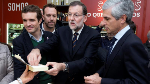 Mariano Rajoy, el vicesecretario de Comunicación, Pablo Casado, y Adolfo Suárez Illana, en una conocida tienda de dulces de Ávila prueban las famosas 'yemas de Ávila' durante el acto de campaña celebrado este viernes en la capital abulense.