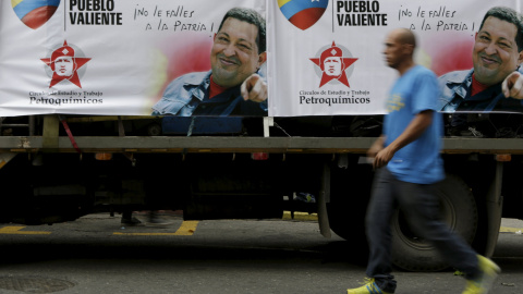 Un hombre pasa por Caracas junto a un camión con carteles electorales con la imagen del fallecido presidente velezolano Hugo Chávez. REUTERS / Marco Bello