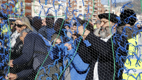 Militantes de la izquierda abertzale colocan lazos en favor de la independencia durante la manifestación que ha recorrido las calles de Bilbao en contra de la Constitución española, coincidiendo con la celebración de su aniversario, y en de