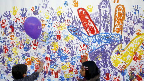 Niños pintando en un muran en el acto de Podemos en Madrid, junto al Museo Reina Sofía, en el que ha intervenido el líder del partido Pablo Iglesias. REUTERS/Susana Vera