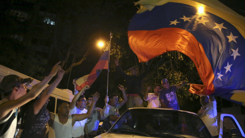 Los partidarios de la oposición ondean la bandera de Venezuela mientras celebran el resultado de las elecciones generales del país latinoamericano. REUTERS/Nacho Doce
