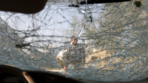 Un hombre afgano se ve desde el interior de un coche bomba tras explotar en la provincia de Nangarhar, Afghanistan. REUTERS/Parwiz