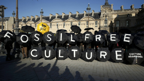 Activistas protestan frente a la pirámide del Louvre en París para pedir al museo que cancele sus contratos con la petrolera francesa Total y la italiana Eni. REUTERS/Benoit Tessier