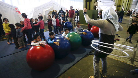 Niños juegan en un refugio para inmigrantes dentro de un hangar del antiguo aeropuerto de Tempelhof, en Berlín. REUTERS/Fabrizio Bensch