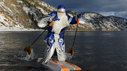 Nikolai Vasilyev, de 62 años, vestido como Papá Noël, el equivalente ruso de Santa Claus, hace esquí acuático a lo largo del río Yenisei fuera de la ciudad siberiana de Krasnoyarsk, Rusia, 10 de diciembre de 2015. REUTERS / Ilya Naymushin