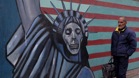 Un hombre iraní camina junto a un mural en la pared de la antigua embajada de Estados Unidos en Teherán. REUTERS/Raheb Homavandi