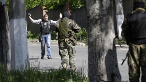 Un reportero de guerra obedece las órdenes de milicianos prorrusos en Donetsk.-  REUTERS