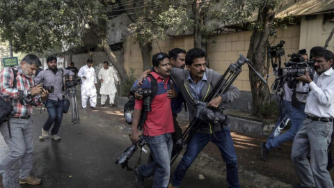 Periodistas paquistaníes ayudan a un fotógrafo herido durante una manifestación.- EFE