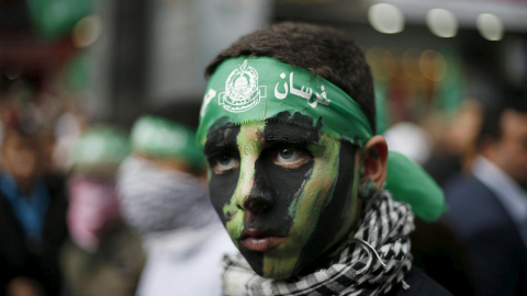 Niño palestino con el rostro pintado participa en una manifestación por el 28 aniversario de la fundación de Hamas, en la ciudad de Gaza.  REUTERS/Suhaib Salem