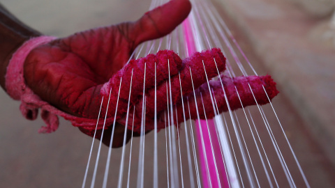 Un trabajador aplica color a las cuerdas que se utilizan para volar cometas en Ahmedabad, India. REUTERS / Dave Amit