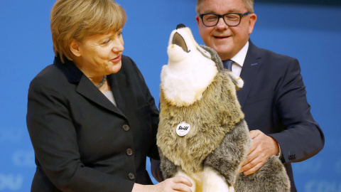 La canciller alemana Angela Merkel recibe un perro de juguete como regalo durante un congreso del partido CDU en Karlsruhe, Alemania.  REUTERS/Kai Pfaffenbach