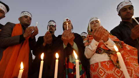 Varias personas rezan durante el aniversario del ataque a una escuela gestionada por militares en Peshawar, Pakistán. EFE/Bilawal Arbab