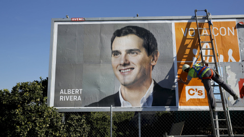 Un operario termina de colocar un cartel electoral de Albert Rivera en Gelves, cerca de Sevilla. REUTERS/Marcelo del Pozo