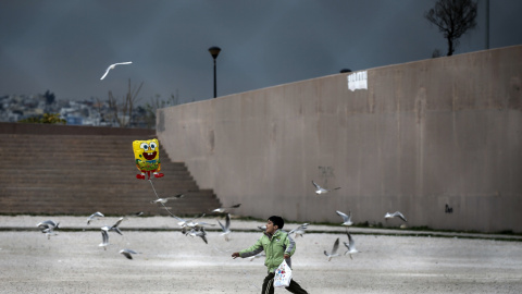 Un pequeño inmigrante juega con un globo de Bob Esponja, cerca del suburbio de refugiados instalado en Atenas. REUTERS/Alkis Konstantinidis