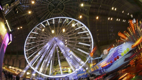 Unos niños disfrutan de las atracciones de la Feria 'Jours de Fetes', situada en Gran Palacio de París como parte de las actividades de vacaciones en París. REUTERS/Philippe Wojazer