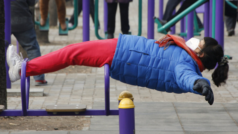 Una niña juega en un parque infantil de Pekín. Pese a estar muy por encima de los 25 microgramos recomendados por la Organización Mundial de la Salud (OMS), no llega a los 200 que las autoridades estipulan para decretar la alerta roja cuand