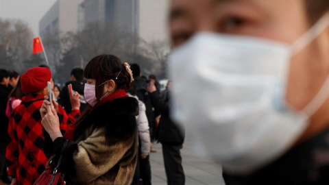 Un hombre ataviado con una máscara anticontaminación mira a la cámara en Pekín (China). La Embajada de EE.UU. en la ciudad establece como "no saludable" los niveles de entre 150 y 200 microgramos por metro cúbico de partículas finas PM 2,5 