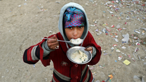 Una niña come en el campo de desplazados internos (IDP) de Kabul, Afganistán, hoy 21 de diciembre 2015. La crisis de los refugiados afganos es la más larga jamás registrada en la historia de ACNUR, dado que 36 años después de las primeros h