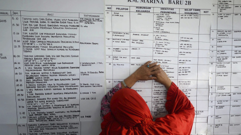 Una mujer indonesia llora mientras comprueba la lista de pasajeros en un centro de crisis para familiares de los 122 pasajeros del transbordador que naufragó este fin de semana en Siwa (Indonesia)./EFE