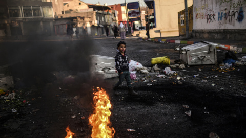 Un niño kurdo camina detrás de las barricadas durante una manifestación en contra de las operaciones de seguridad contra los rebeldes kurdos en las ciudades turcas sudeste Cizre y Silopi./ AFP/BULENT KILIC