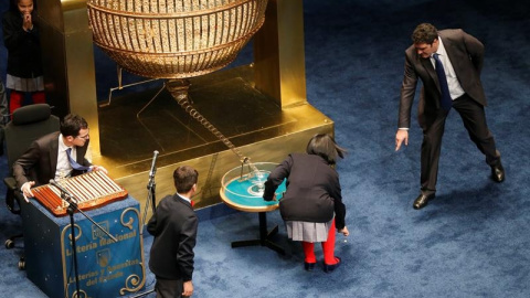 Los niños de San Idelfonso recogen una bola premiada con mil euros que se había caido al suelo. EFE/Juan Carlos Hidalgo