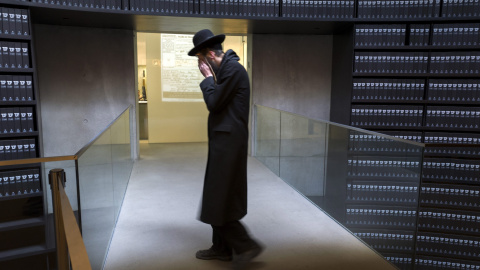 Un judío ultraortodoxo pasa junto a las carpetas que guardan documentación de alrededor cuatro de los seis millones de judíos exterminados por los nazis durante la II Guerra Mundial, mientras visita el 'Salón de los Nombres' del Museo del H