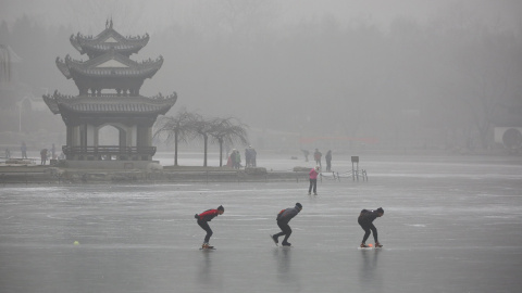 Personas patinan en un lago congelado en el Parque Taoranting durante un día brumoso, en Pekín, China. REUTERS / Stringer,