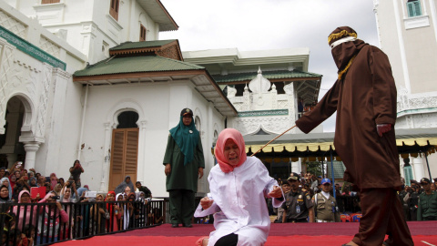 Nur Elita, grita mientras la golpean en el patio de la mezquita Baiturrahman en Banda Aceh, la provincia indonesia de Aceh 28 de diciembre de 2015. Nur Elita recibió cinco golpes de vara por tener relaciones sexuales antes del matrimonio co