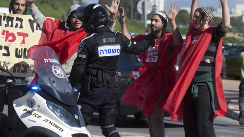 Un grupo de judíos colonos de derechas levanta sus manos ante las órdenes de la policía durante una protesta en las afueras del juzgado de paz en Petah Tikvav, cerca de Tel Aviv, Israel, hoy 28 de diciembre 2015.  EFE/Jim Hollander