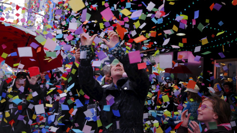 Los peatones se detienen a ver la caída de confeti mientras miembros de la Alianza de Times Square realizan una "prueba de la solvencia del aire " para el confeti que es similar a lo que va a ser utilizado para la víspera de Año Nuevo en Nu