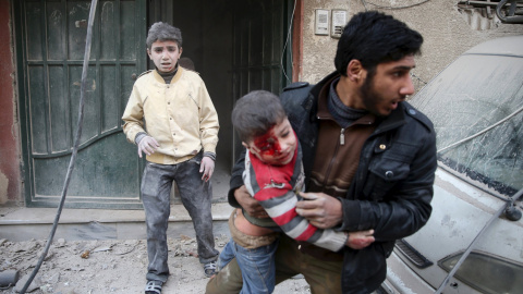 Un hombre saca a un niño herido  de un edificio dañado de los ataques de las fuerzas leales al presidente Bashar al-Assad según denuncian los activistas de la zona en Douma, al este de Ghouta en Damasco, Siria 30 de diciembre de 2015. REUTE