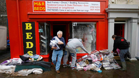 Varias personas recuperan objetos de un local en Newton Stewart (Escocia) tras las riadas. REUTERS/Darren Staples