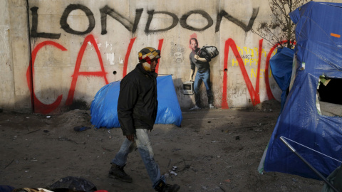Un inmigrante junto a una pared con un mural pintado por Bansky en el paso de Calais. REUTERS/Pascal Rossignol