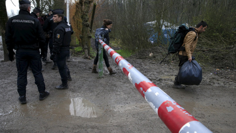 Los gendarmes franceses controlan la entrada de inmigrantes en el campamento provisional para refugiados de procedentes de Irak, Kurdistán, Irán y Siria, cerca de Dunkerque (Francia). REUTERS / Pascal Rossignol