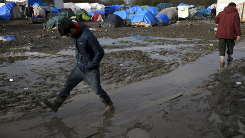 Un inmigrante camina por el suelo enfangado del  campamento provisional para refugiados de procedentes de Irak, Kurdistán, Irán y Siria, cerca de Dunkerque (Francia). REUTERS / Pascal Rossignol