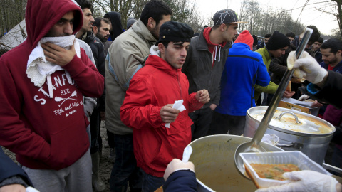 Los inmigrantes hacen cola para la comida en un campamento provisional para refugiados de procedentes de Irak, Kurdistán, Irán y Siria, cerca de Dunkerque (Francia). REUTERS / Pascal Rossignol