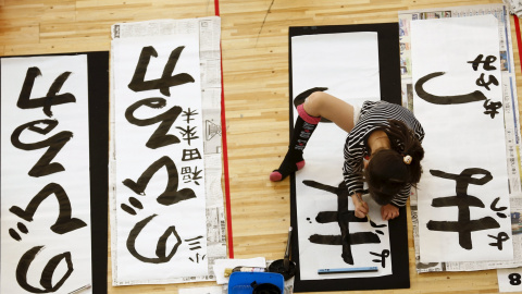 Una niña participa en un concurso de caligrafía para celebrar el Año Nuevo en Tokio. REUTERS/Thomas Peter