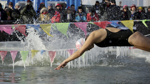 Un nadador se sumerge en una piscina en el hielo que cubre el río Songhua durante una competición de natación en la ciudad de Harbin, en China. REUTERS/Aly Song