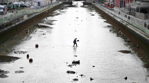 Un trabajador entra en el agua durante el drenaje del Canal Saint-Martin en París. REUTERS/Charles Platiau