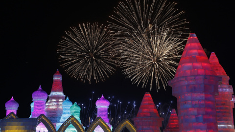 Fuegos artificiales iluminan el cielo tras las esculturas de hielo en la jornada inaugural del Festival Internacional de hielo y nieve de Harbin, en la provincia de Heilongjiang, en China. REUTERS/Aly Song