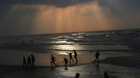 Jóvenes palestinos pasan la tarde en la playa de Gaza durante una puesta de sol, el 3 de enero de 2016.- EFE/EPA/MOHAMMED SABER