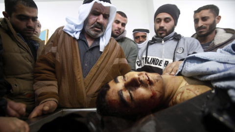 Familiares y médicos observan el cuerpo de Ahmad Kawazbeh, de 17 años, en un hospital de la ciudad cisjordana de Hebrón, Palestina, el 5 de enero de 2016. Kawazbeh fue asesinado por las fuerzas de seguridad israelíes después de que intentar