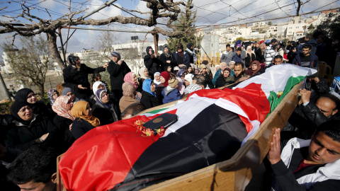 Los dolientes llevan el cuerpo de la palestina Mahdia Hamad, de 38 años, durante su funeral en Silwad cerca de la ciudad cisjordana de Ramala, el 26 de diciembre de 2015. Los policías fronterizos israelíes mataron a Hamad después de que que