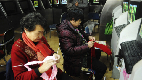 Dos inversoras hacen punto en una agencia de corredores de Qingdao, provincia de Shandong, China. EFE/Yu Fangping