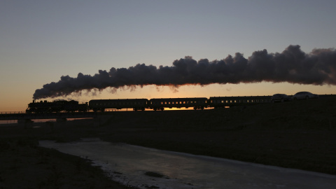 Un tren de vapor viaja entre campos de cultivo durante el amanecer en Diaobingshan, en China. REUTERS/Sheng Li